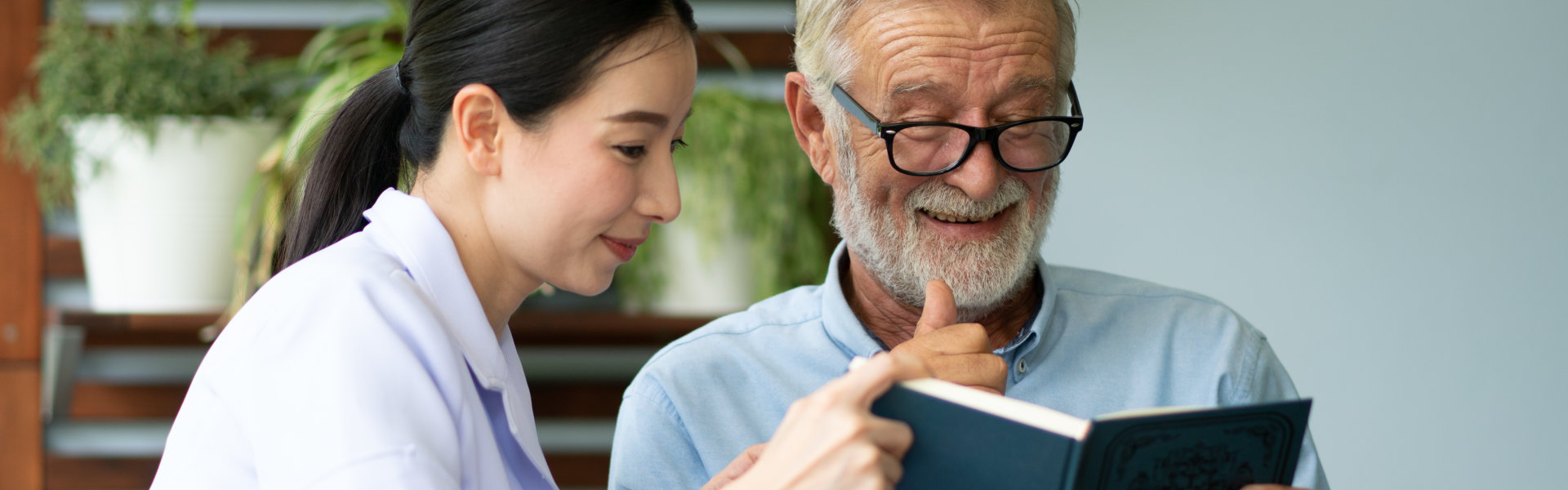 nurse and senior man reading book
