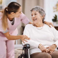 woman nurse and senior woman on wheelchair smiling