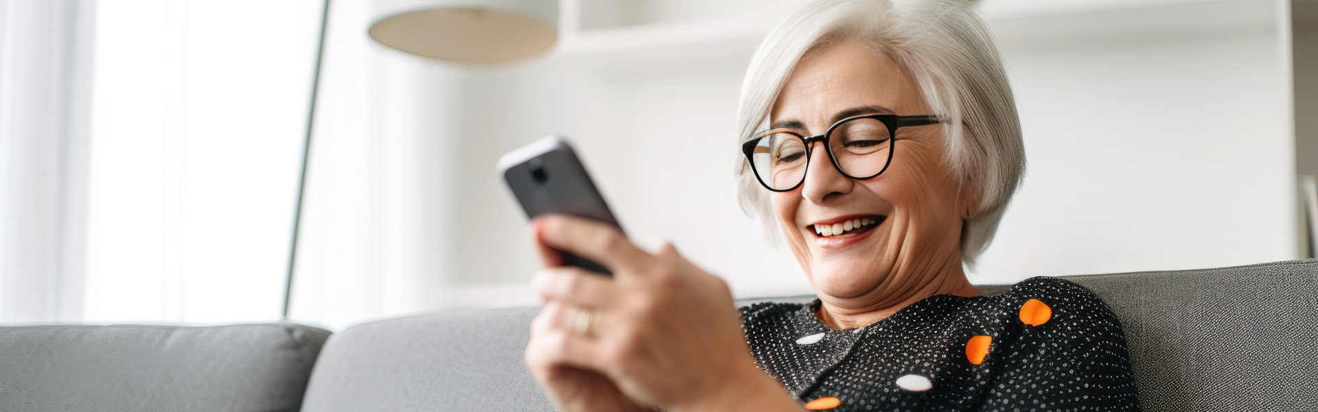 an elderly woman smiling while holding a mobile phone
