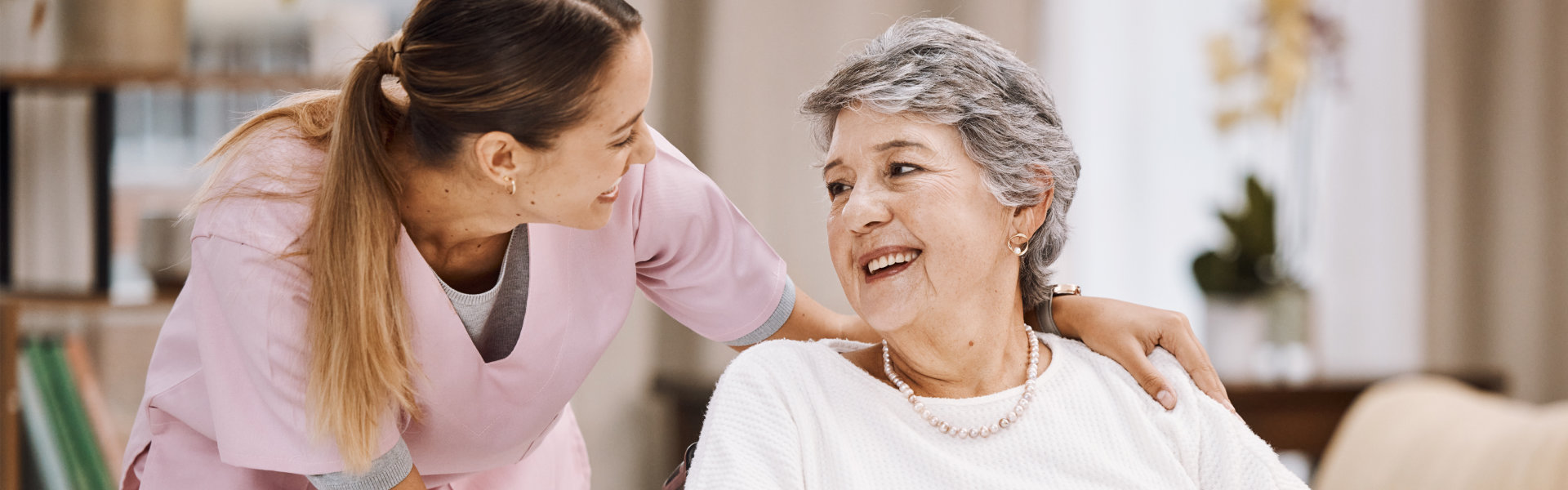 woman nurse and senior woman on wheelchair smiling