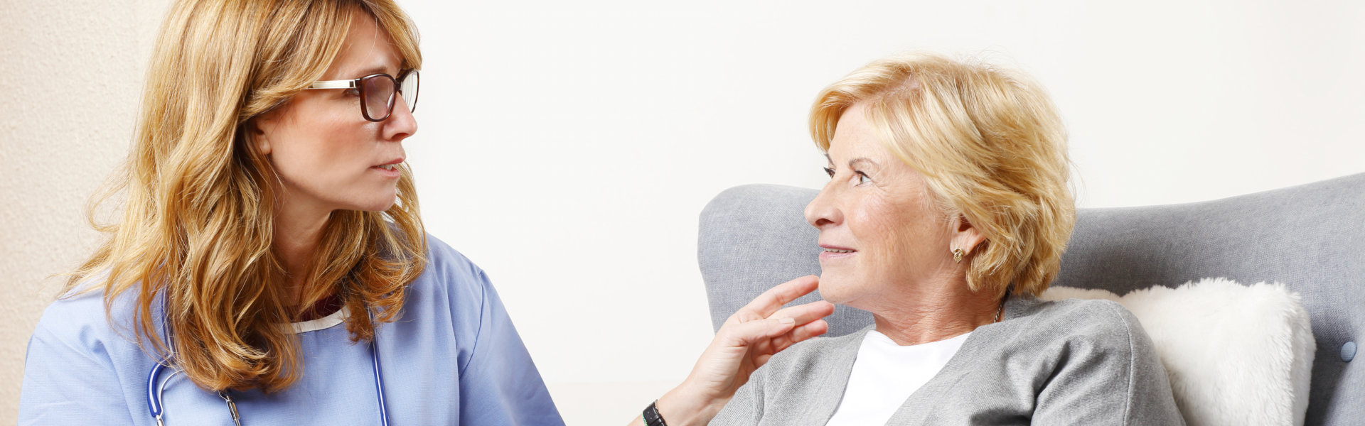 senior woman and nurse smiling
